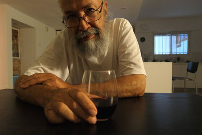 Senior man drinking wine at home 