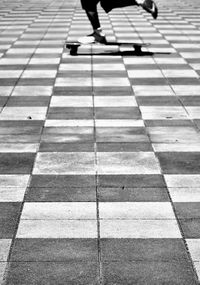 Low section of person walking on tiled floor
