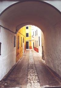 Walkway amidst brick wall