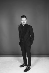 Portrait of young man standing against wall