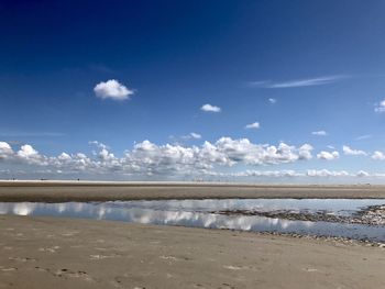 Scenic view of beach against blue sky