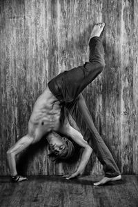 Full length of young man dancing against wall