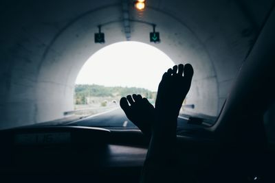 Low section of woman standing in tunnel