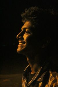 Portrait of young man against black background