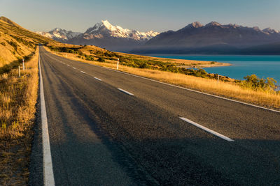 Road by mountains against sky