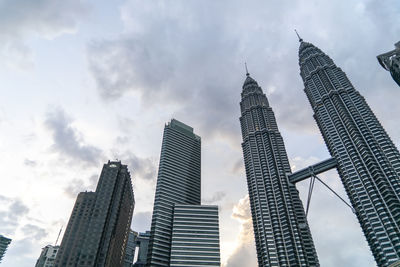 Low angle view of buildings against cloudy sky