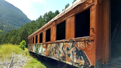 Abandoned train on railroad track against sky