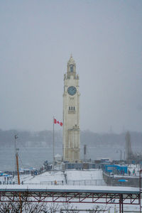 Clock tower in winter against sky