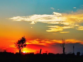 Scenic view of silhouette landscape against orange sky