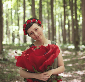 Portrait of woman standing on red rock in forest