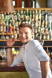 Smiling young man looking away while sitting at restaurant