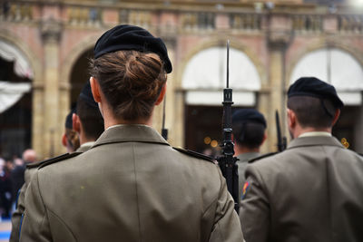 Rear view of female police with rifle in city