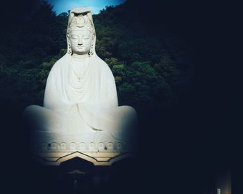 Statue of buddha against trees