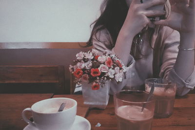 Midsection of woman with coffee beans on table