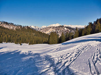 Scenic view of snowcapped mountains against clear blue sky