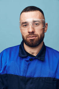 Portrait of young man against blue background