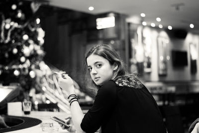 Portrait of young woman holding cigarette