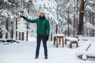 Portrait of man standing on snow covered land