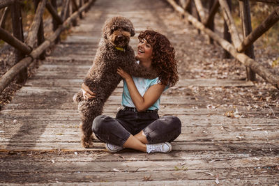 Portrait of young woman sitting on footpath