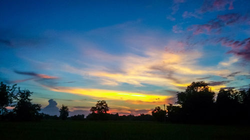 Silhouette landscape against dramatic sky during sunset