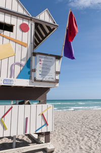 A wooden lifeguard station on miami beach with warning flags on the beach, florida, usa