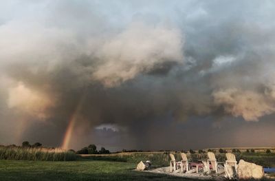 Scenic view of rainbow over field against sky