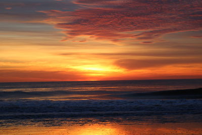 Scenic view of sea against orange sky during sunrise 