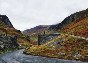 Road by mountain against sky