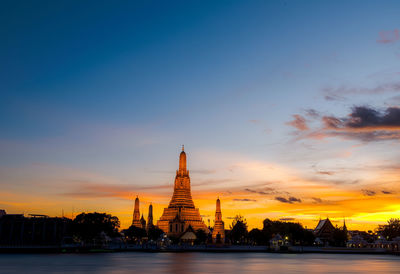 Golden gate of temple against sky during sunset