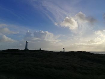 Silhouette person on landscape against sky