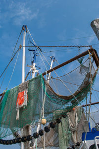 Fishing net hanging on rope against sky