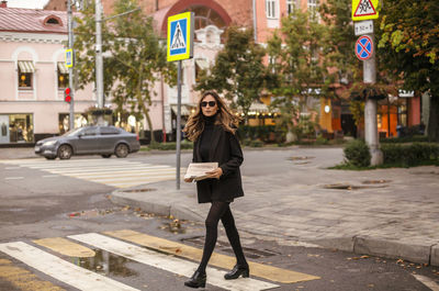 Portrait of woman walking on street in city