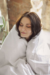 Portrait of young woman lying on bed