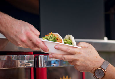 Close-up of hand holding food on table