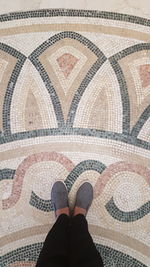 Low section of man standing on tiled floor