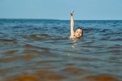 7-8 years old cute caucasian boy swimming in the sea