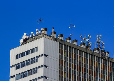 Low angle view of buildings against clear blue sky