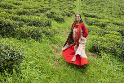 Graceful young lady enjoying the nature in a lash green tea garden 