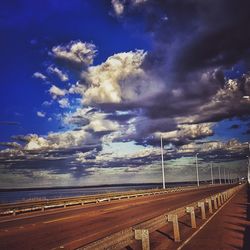 Road by sea against blue sky