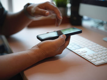 Close-up of man using laptop on table