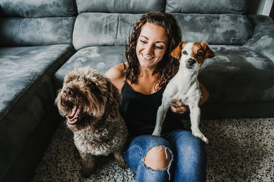 Woman with dogs sitting on sofa