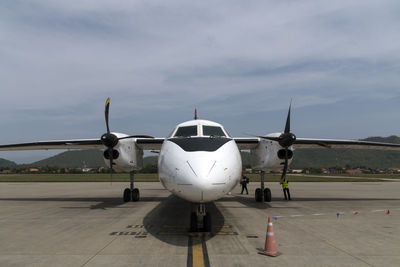 Airplane on runway against sky