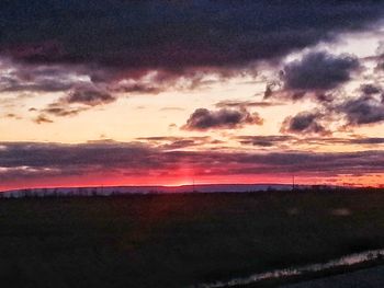 Scenic view of dramatic sky over field