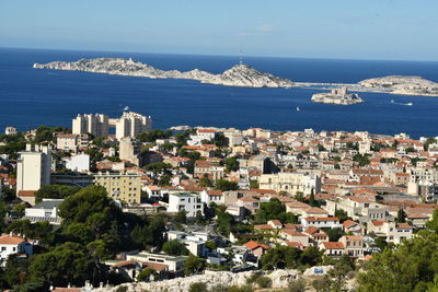 High angle view of townscape by sea against sky