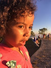 Close-up of cute girl looking away while standing outdoors