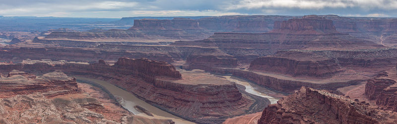 Rugged beauty of red sandstone cliffs of canyon with valley below evokes the old west