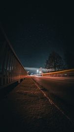 Illuminated bridge against sky at night