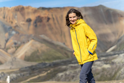 Young woman in a bright jacket on a sunny day in iceland's highlands