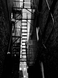 Low angle view of fire escape amidst old buildings in city