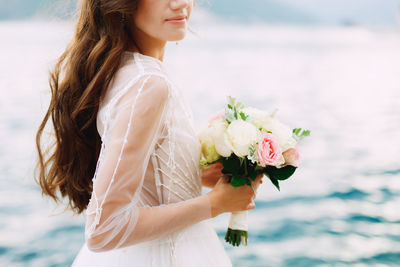 Midsection of woman holding flower bouquet